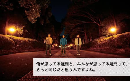 Three members of susquatch standing on a tree-lined road at night