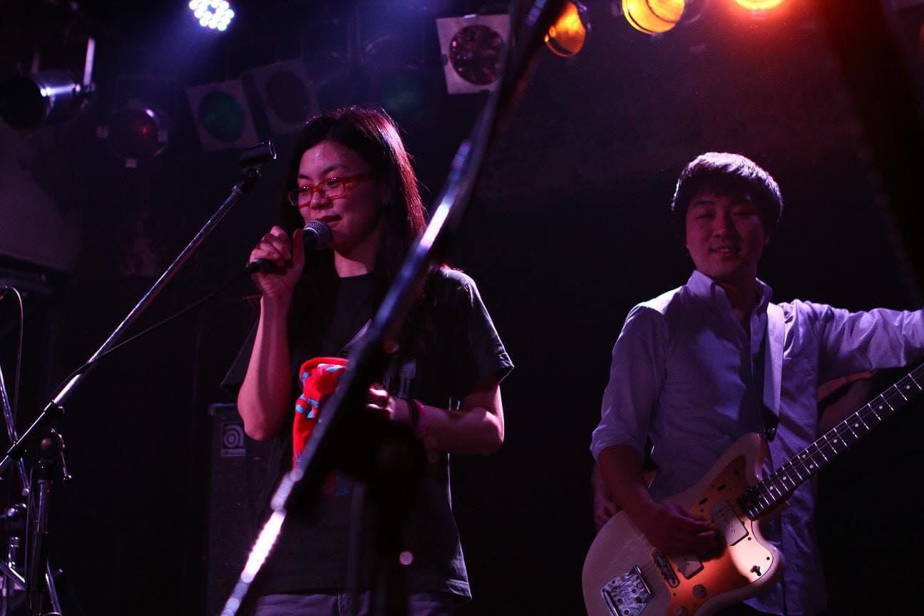 Two musicians onstage under purple and orange lights