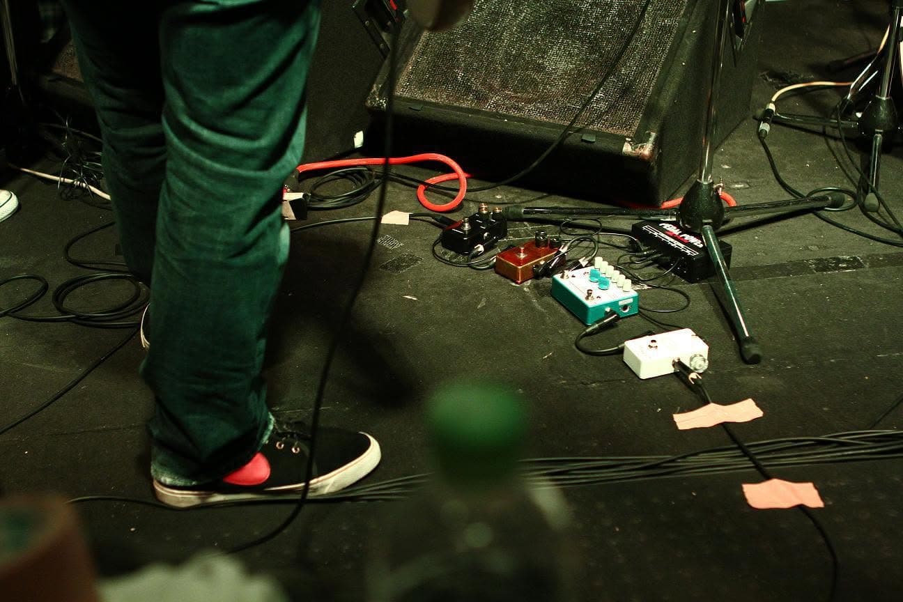 Guitar pedals and cables on a venue stage